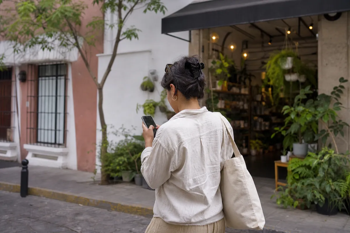 Cliente buscando un negocio en el mapa de su teléfono frente a la tienda