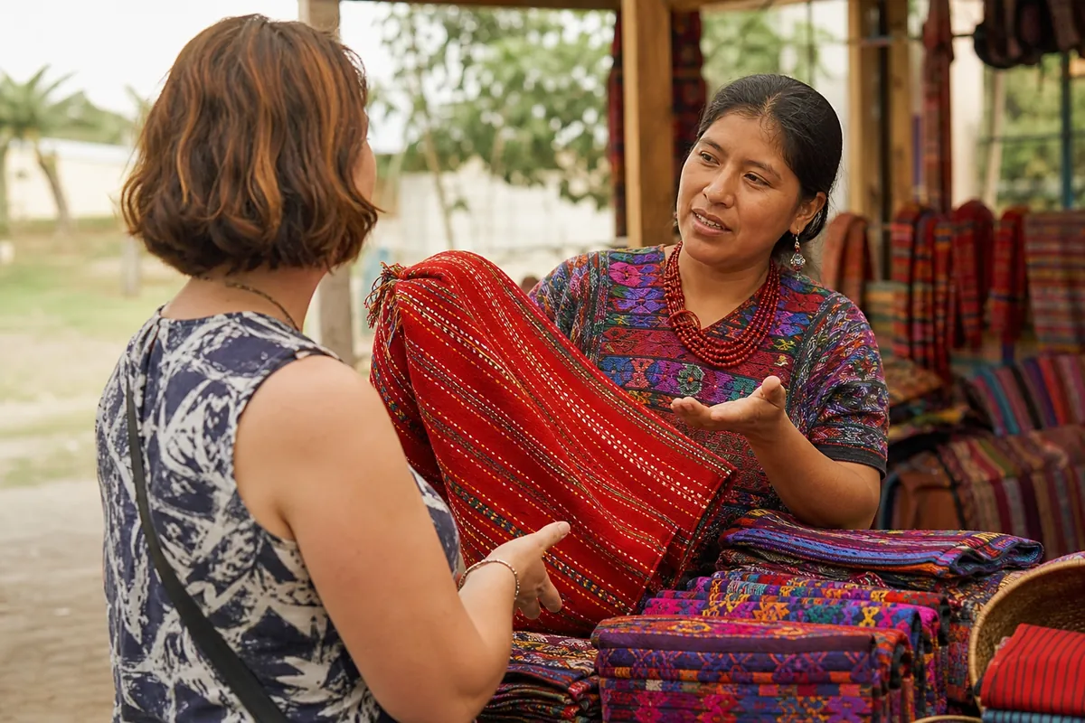 Vendedora explicando un producto artesanal a un cliente en un puesto