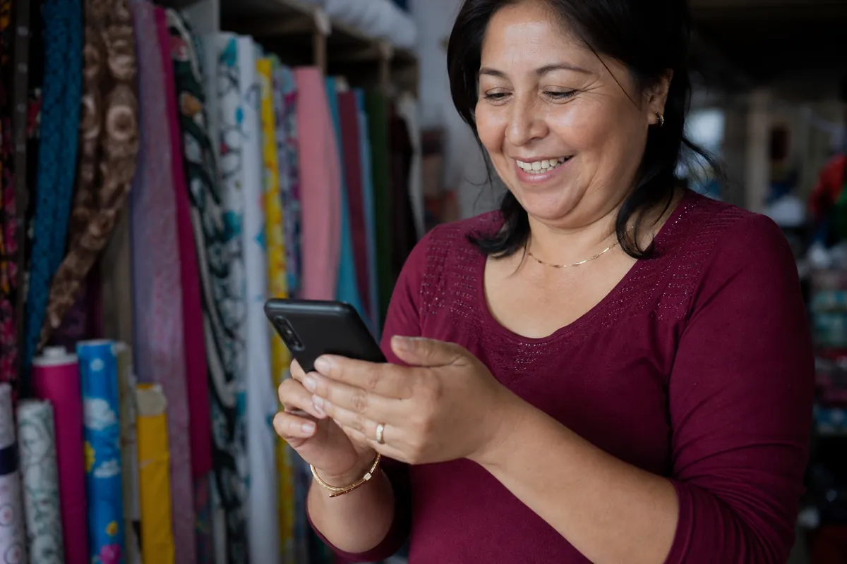 Dueño de una tienda escribiendo rápido en su teléfono